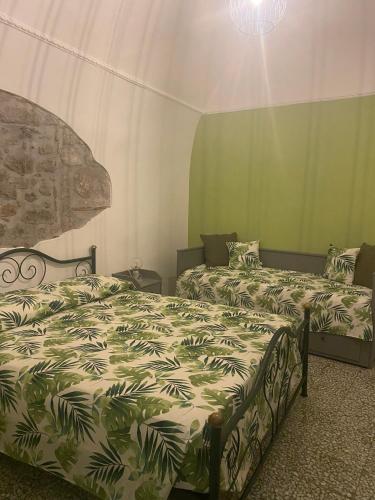 two beds in a room with green walls at aCasetta GuestHouse in Viterbo