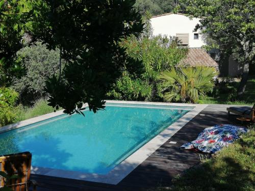 einen Pool in einem Garten mit Bäumen in der Unterkunft Charmant logement provençal avec piscine à deux pas du village médieval in Seillans
