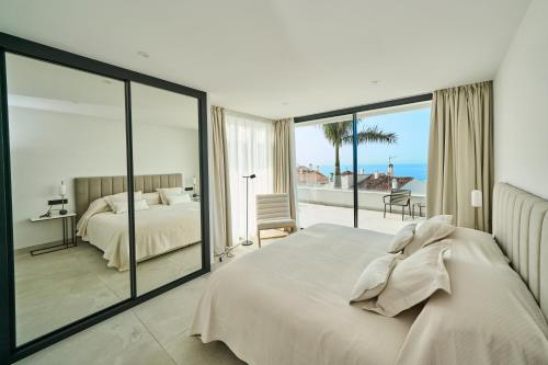a bedroom with a bed and a view of the ocean at Sea Gardens Villa in Nerja