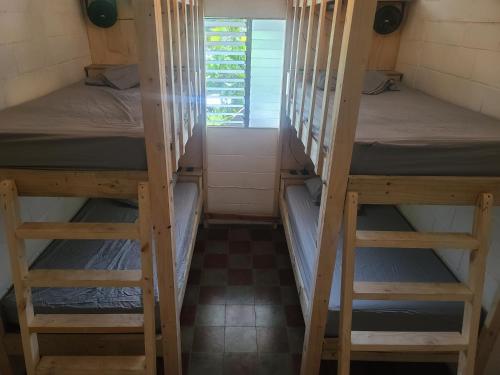 two bunk beds in a small room with a window at Hammock plantation in El Zonte