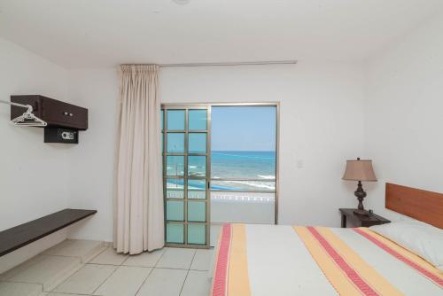 a bedroom with a bed and a view of the ocean at Hotel La Trigueña in Isla Mujeres