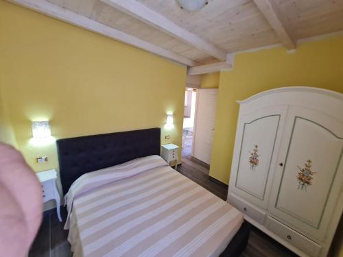 a small bedroom with a bed and yellow walls at DONNA FILOMENA Residence in Marina di Camerota