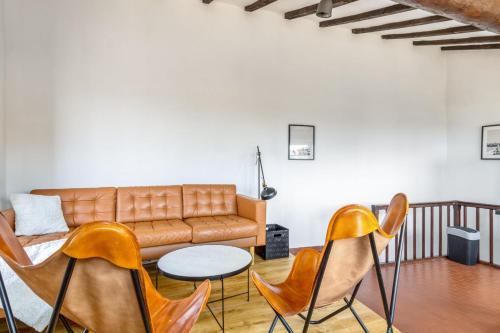 un salon avec un canapé et des chaises dans l'établissement Appartement des Cigales - Welkeys, à Cagnes-sur-Mer