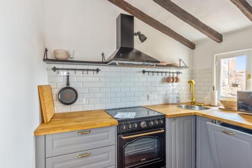 Il comprend une cuisine équipée d'une cuisinière. four supérieur à côté d'un évier dans l'établissement Appartement des Cigales - Welkeys, à Cagnes-sur-Mer