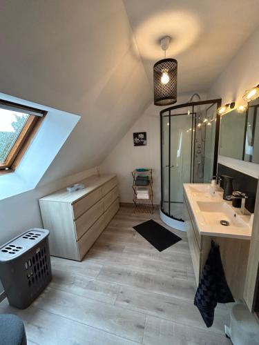 uma casa de banho no sótão com um lavatório e um chuveiro em Chambre mont saint Michel em Huisnes-sur-Mer