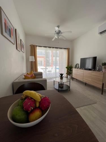 ein Wohnzimmer mit einer Obstschale auf dem Tisch in der Unterkunft Casa Mulata Coral Village Pool & Playa 2 in Punta Cana