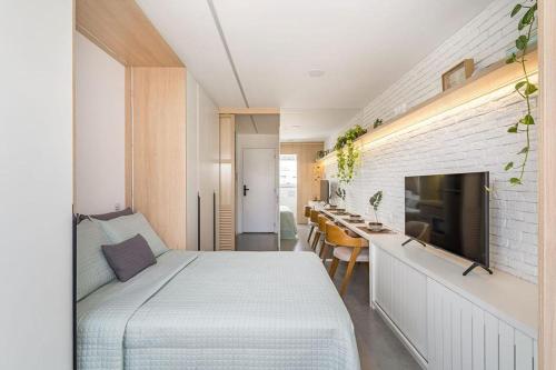 a bedroom with a bed and a wall with a tv at Moov 916 Studio Mooca in Sao Paulo