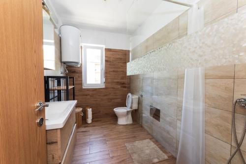 a bathroom with a toilet and a sink and a shower at Lynx and Fox apartment in Delnice