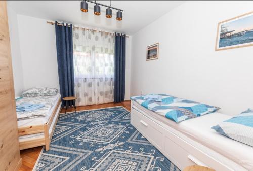 1 dormitorio con 2 camas y alfombra en Lynx and Fox apartment, en Delnice