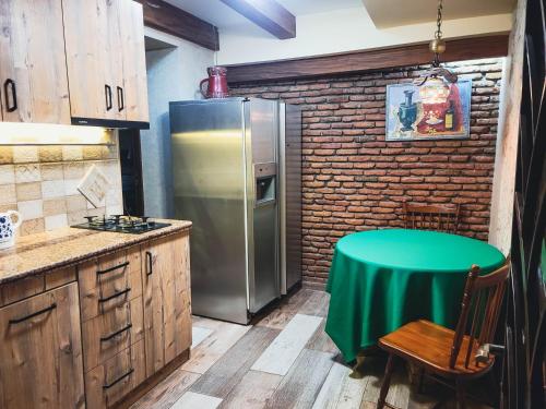 a kitchen with a green table and a refrigerator at City Center Van Gogh Suite in Tbilisi City
