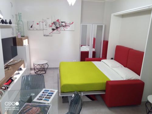 a bedroom with a green bed and red chairs at Civico 6 in Peschiera del Garda