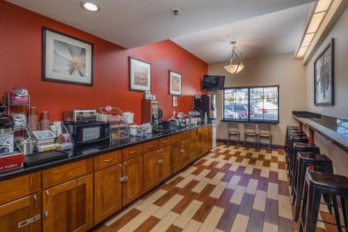 a restaurant with red walls and a counter and chairs at Hotel Skye San Francisco Airport SFO FREE SHUTTLE! in San Bruno