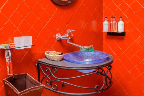 a bathroom with a blue sink in an orange wall at Jet Villas Entebbe ( JVE ) in Entebbe