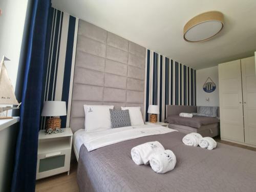 a bedroom with a bed with towels on it at Apartamenty Marynarskie AP10 in Debina