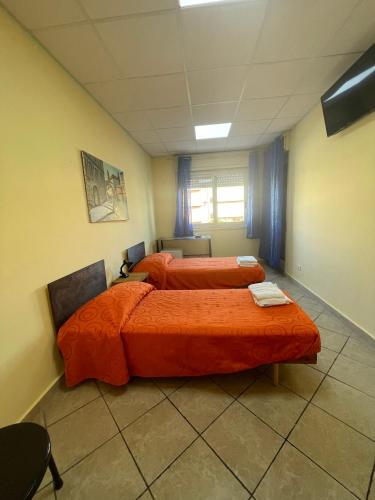 Nuova Gibellina的住宿－Mezz’ora dai mari，配有橙色床单的客房内的两张床