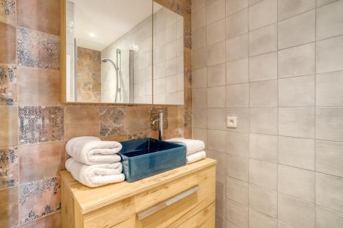 een badkamer met een wastafel en handdoeken op een aanrecht bij Roc Hotel - Hôtel 4 étoiles les pieds dans l'eau in Le Lavandou