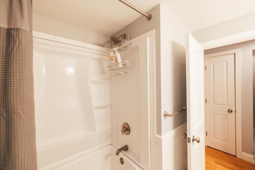 a white bathroom with a shower and a toilet at Spacious Country Home Freeport, 5 min to LL Bean! in Freeport