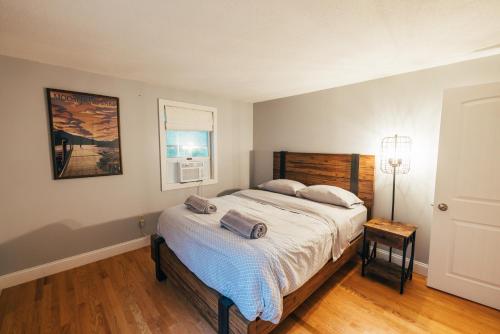 a bedroom with a large bed with a wooden headboard at Spacious Country Home Freeport, 5 min to LL Bean! in Freeport