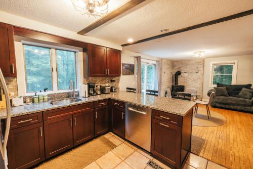 cocina con armarios de madera y sala de estar. en Spacious Country Home Freeport, 5 min to LL Bean!, en Freeport