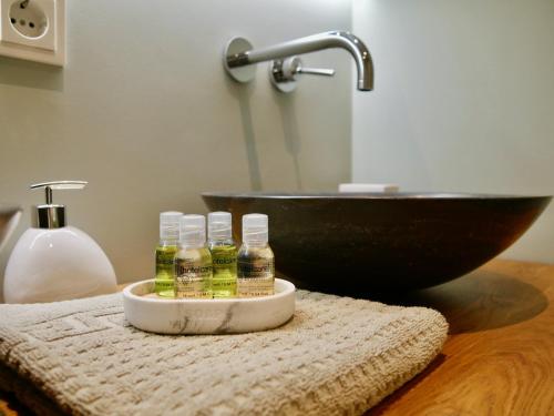 een badkamer met een wastafel en 2 flessen essentiële oliën bij Bed & Breakfast Udens Buiten in Veghel
