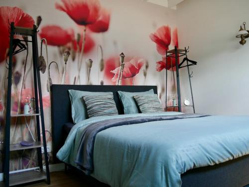 een slaapkamer met een bed met rode bloemen aan de muur bij Bed & Breakfast Udens Buiten in Veghel