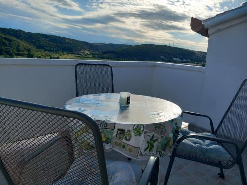 stół i krzesła na balkonie z drinkiem w obiekcie Apartments Mira w mieście Lopar