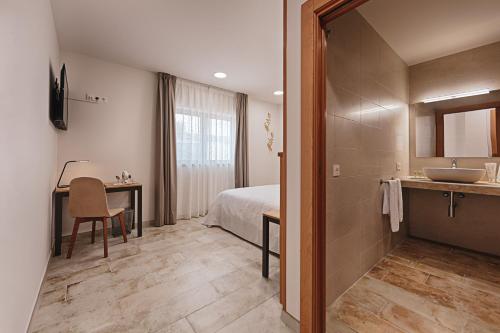 a bathroom with a bed and a sink in a room at Hotel rural La Tejera in Quintanilla de Arriba