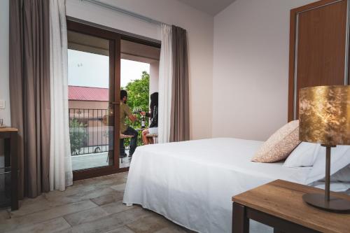 um quarto de hotel com uma cama e uma varanda em Hotel rural La Tejera em Quintanilla de Arriba