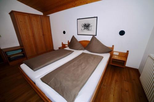 duże łóżko w pokoju z drewnianą podłogą w obiekcie Apartment Krabacher w mieście Seefeld in Tirol