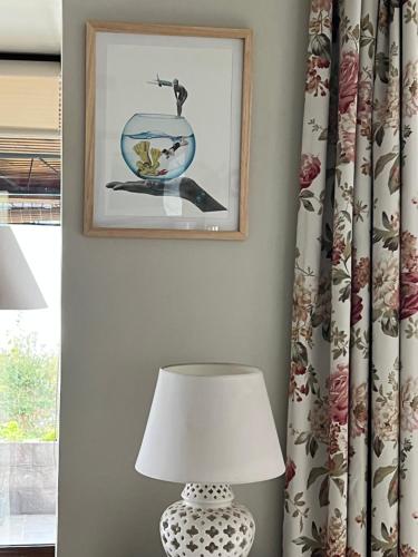a table with a lamp and a picture on the wall at Hotel Boutique Cutipay in Valdivia