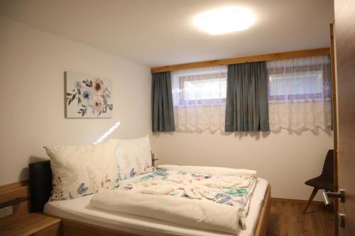 a small bedroom with a bed with a window at Landhaus-Appartements Warraich in Schladming