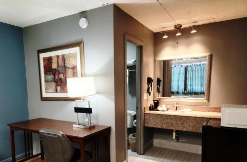 a bathroom with a desk and a sink with a mirror at Executive Inn in Mena