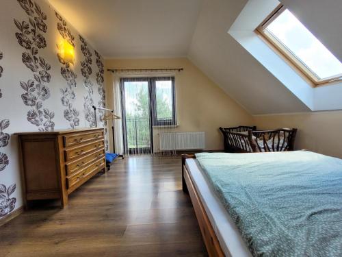 a bedroom with a bed and a skylight at Dom na Wzgórzu in Bakałarzewo