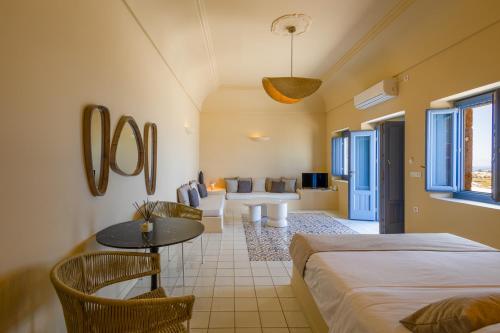 a room with two beds and a table and chairs at Luna Santorini Suites in Pyrgos