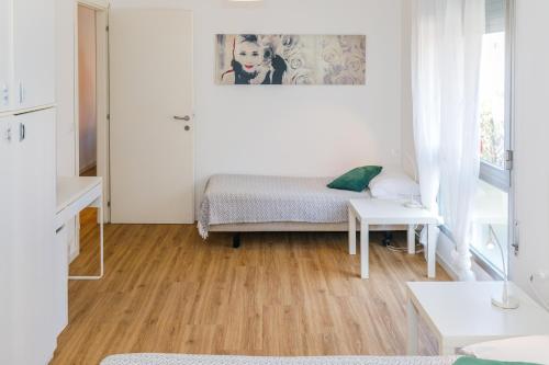 Habitación blanca con cama y mesa en Hapton house Elite2 comodo - FREE PARK - Accesso easy a Venezia, en Mestre