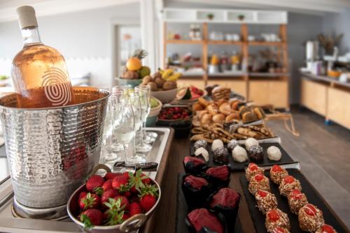 ein Buffet mit Speisen, einer Flasche Wein und Erdbeeren in der Unterkunft White Suites Resort in Afytos