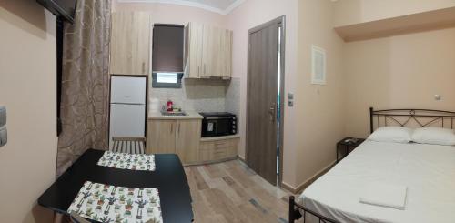 een kleine kamer met een bed en een keuken bij Όμορφο στούντιο στη Χίο! Α2 in Chios
