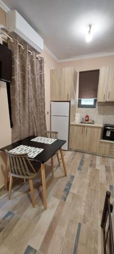 een keuken met een tafel en een keuken met een koelkast bij Όμορφο στούντιο στη Χίο! Α2 in Chios