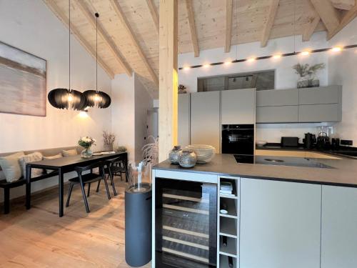 a kitchen and dining room with white cabinets and a table at BergSoul in Garmisch-Partenkirchen