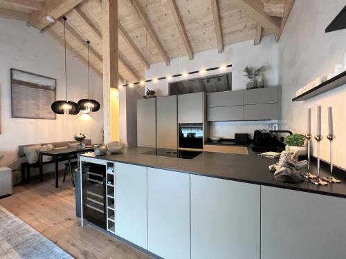 eine Küche mit weißen Schränken und ein Esszimmer in der Unterkunft BergSoul in Garmisch-Partenkirchen