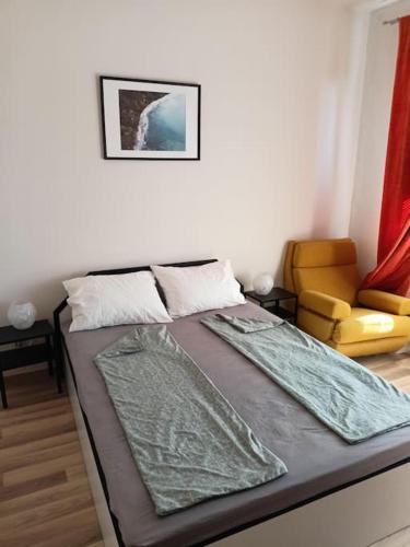 een slaapkamer met een bed en een stoel erin bij Welcome to Daisy sunny place! in Varna