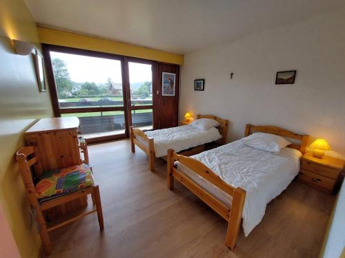 une chambre avec deux lits et une fenêtre dans l'établissement Appartement 37m² avec balcon, 500m centre village et pistes ski, parking privé - Autrans - FR-1-737-40, à Autrans
