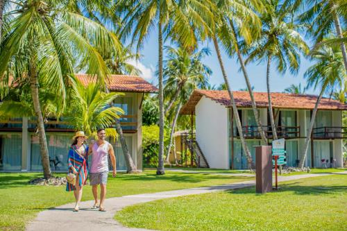 ein Paar geht einen Weg vor einem Resort entlang in der Unterkunft Pratagy Acqua Park Beach All Inclusive Resort in Maceió