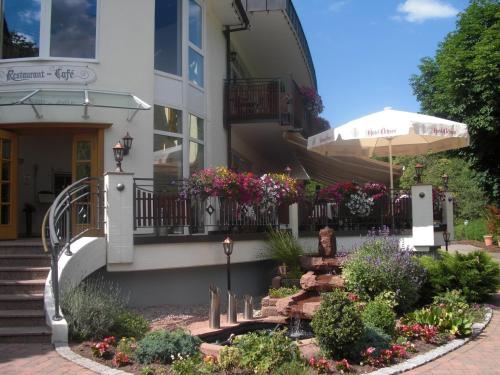 a building with a flower garden in front of it at Hotel Ochsen in Höfen an der Enz