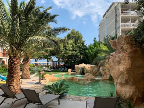 una piscina in un hotel con sedie e un parco acquatico di Hotel Capanna d'Oro a Lignano Sabbiadoro