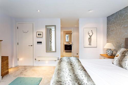 a bedroom with a large white bed and a mirror at Luxury and Modern Bayswater Apartment in London