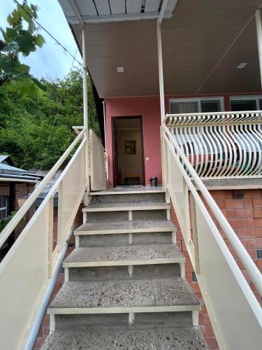 a set of stairs leading to a pink house at Happy Holidays in Borjomi