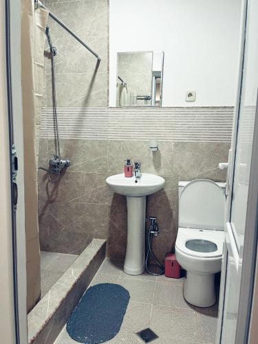 a bathroom with a toilet and a sink and a shower at Happy Holidays in Borjomi