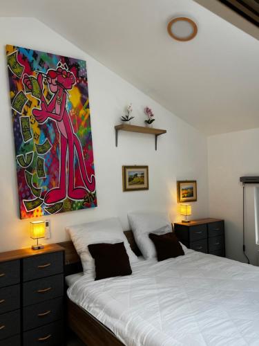 1 dormitorio con 1 cama y una pintura en la pared en Laicas lodge en Dirbach