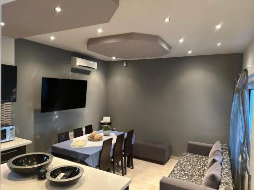 a dining room with a table and a tv at Villa Marmari 1 in Marmarion